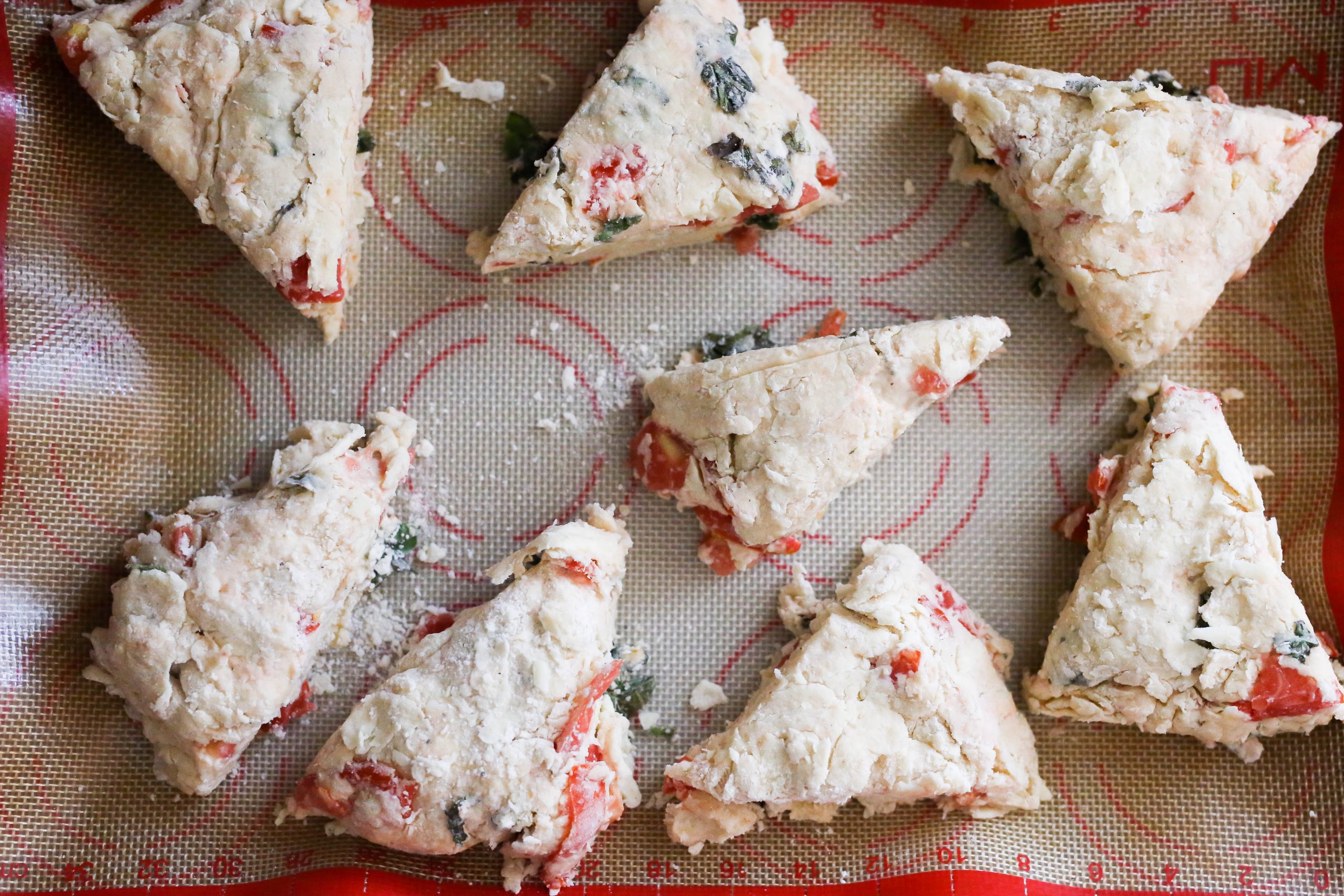 scones lined up on a silicone mat ready for baking