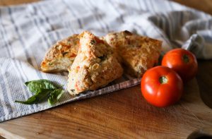 tomato basil scones on towel with tomatoes 