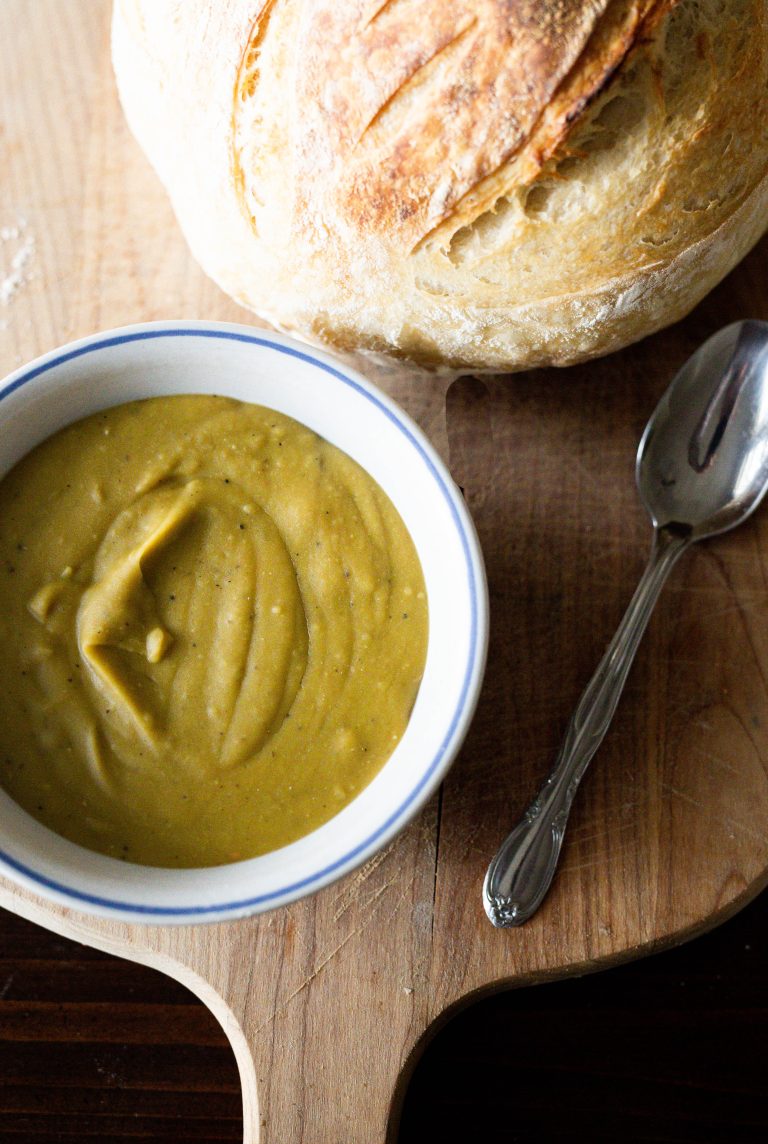 split pea soup with fresh bread on a cutting board