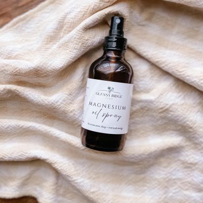 bottle of magnesium oil spray laying on a towel