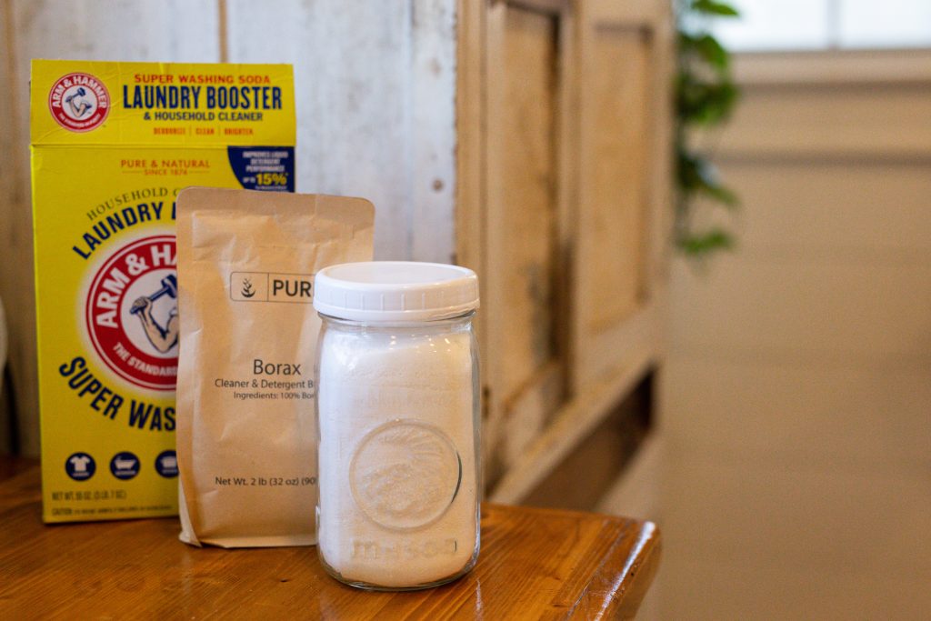 washing soda, borax, and homemade laundry detergent stacked together on a counter