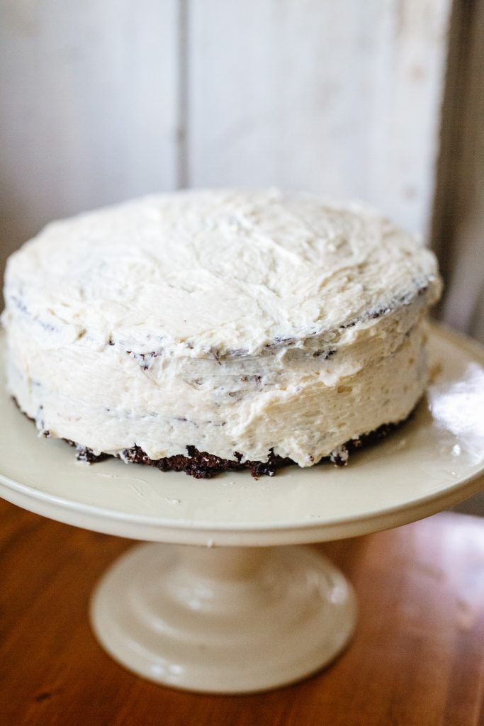 chocolate cake with frosting on a yellow cake stand